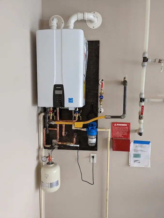 Professional plumber installing copper piping in a Olive home
